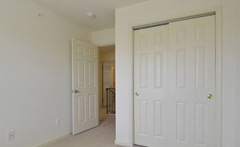 Bedroom with two doors and a hallway in the background at The Pointe at Manorgreen Townhomes, Baltimore Maryland